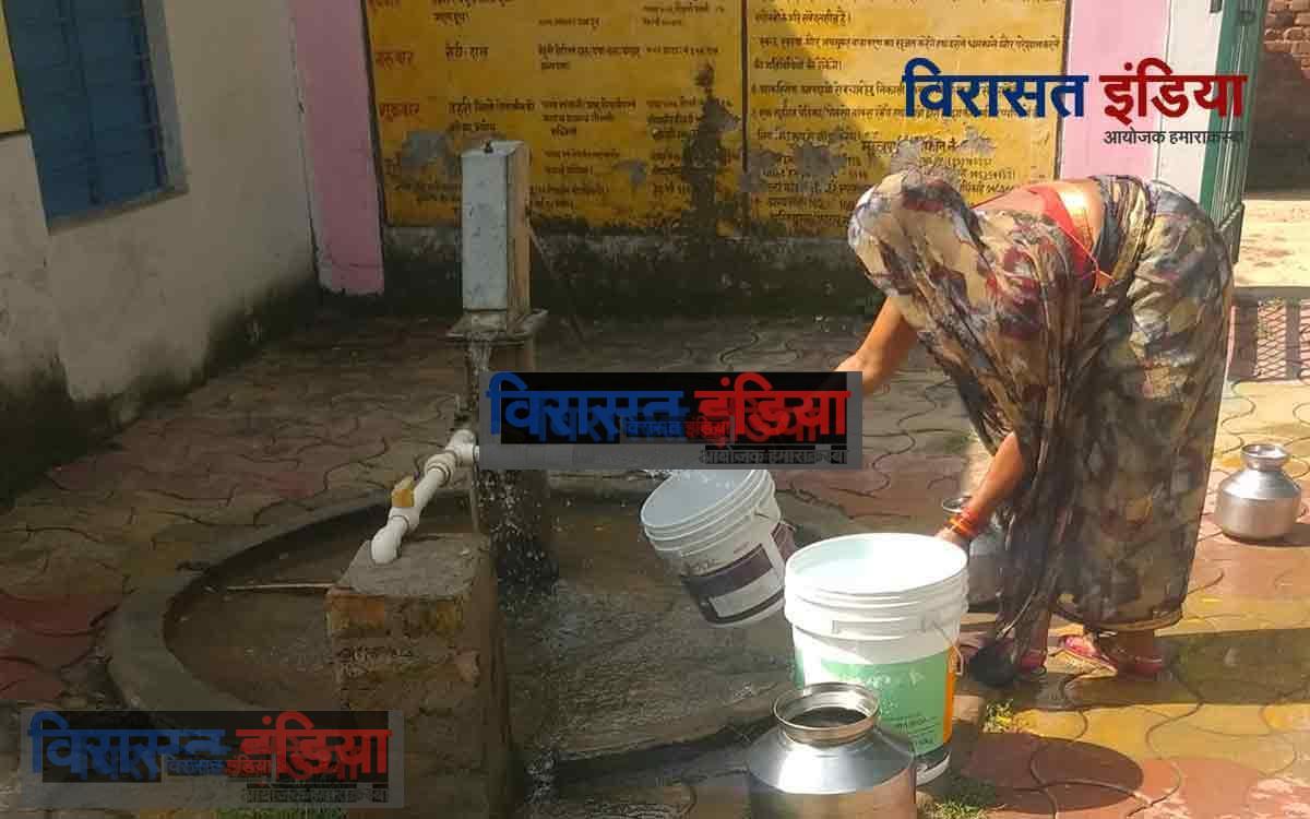 हैंडपंप से पानी भरती महिला
